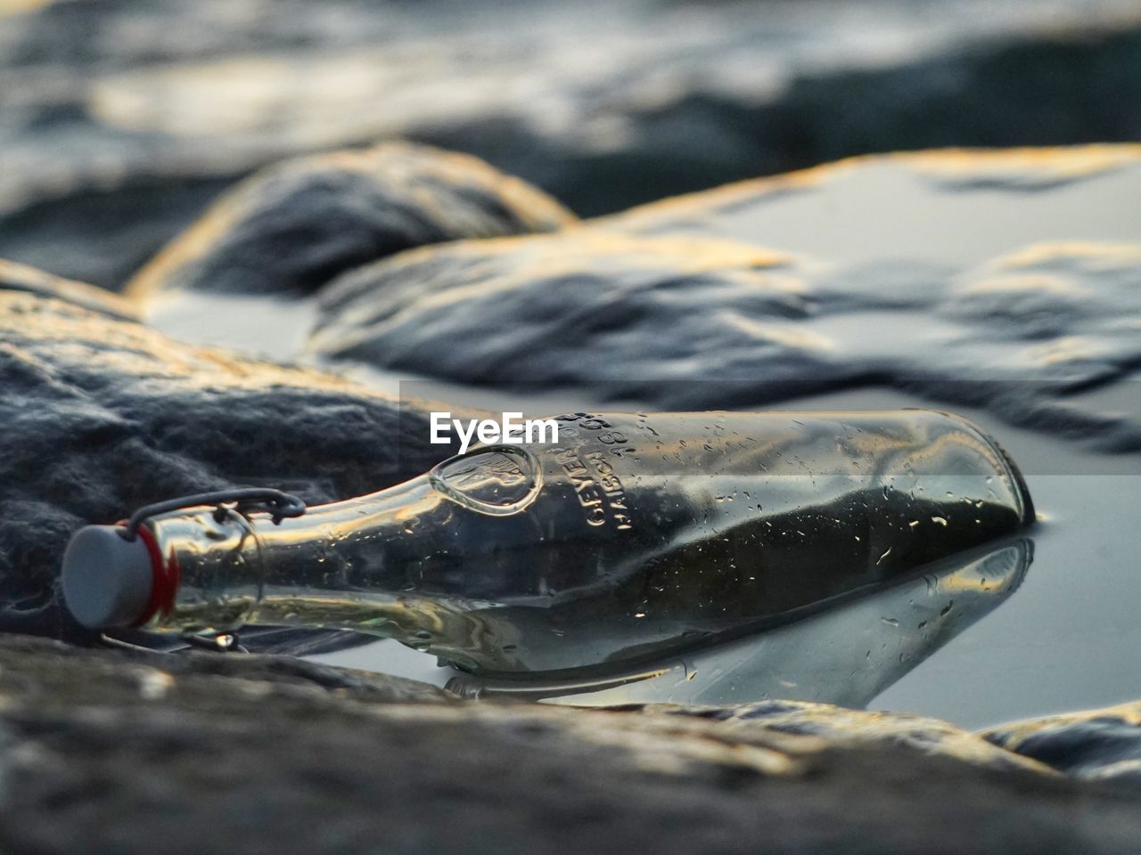 CLOSE-UP OF WET GLASS WITH REFLECTION OF WATER