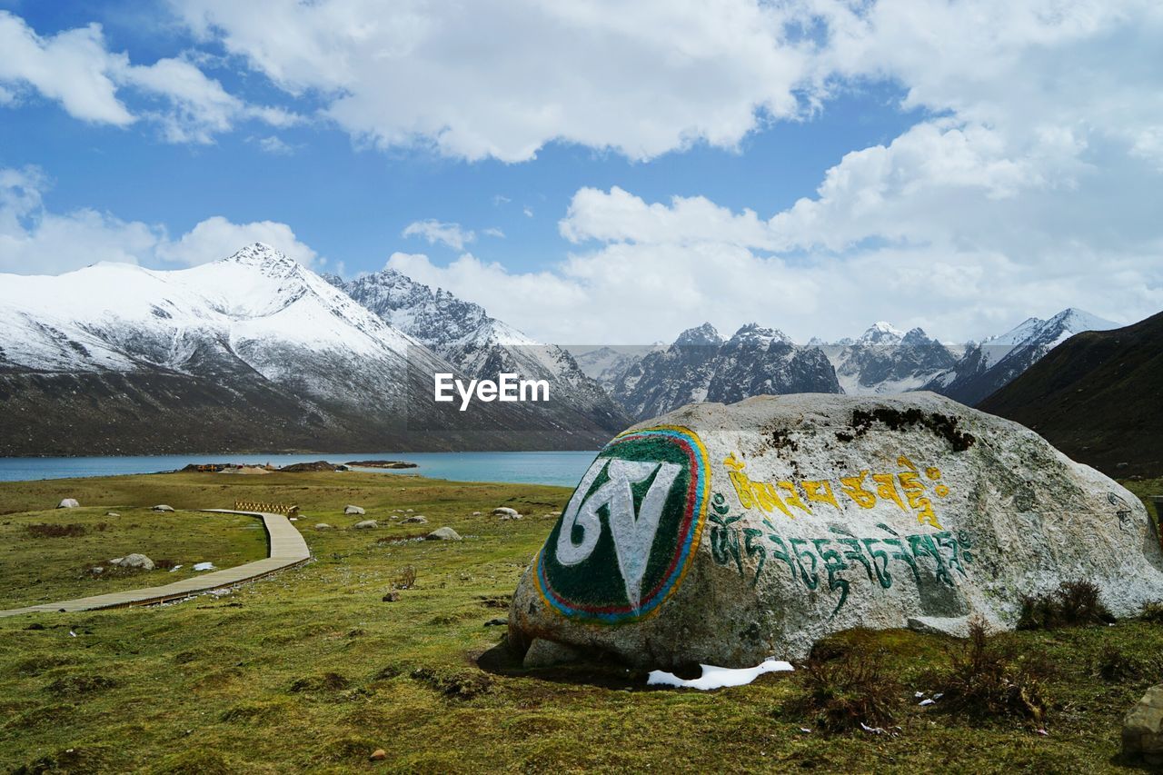 Text written on rock against snowcapped mountains