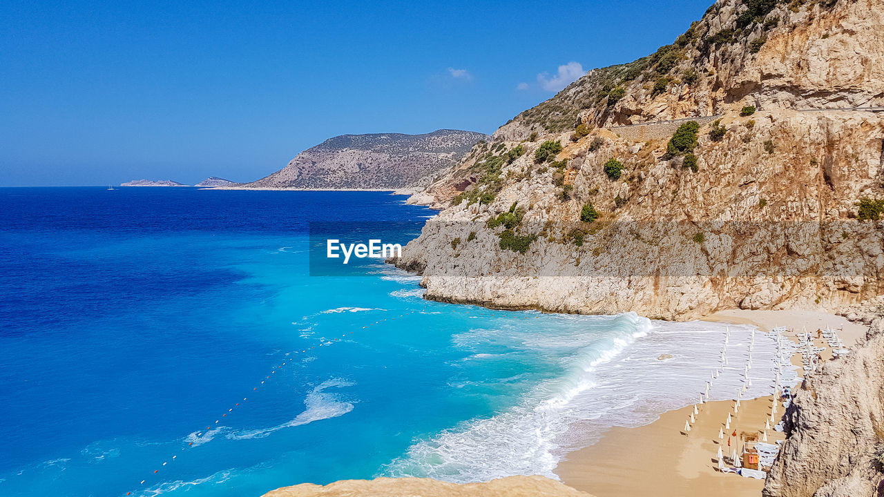 scenic view of beach against clear blue sky