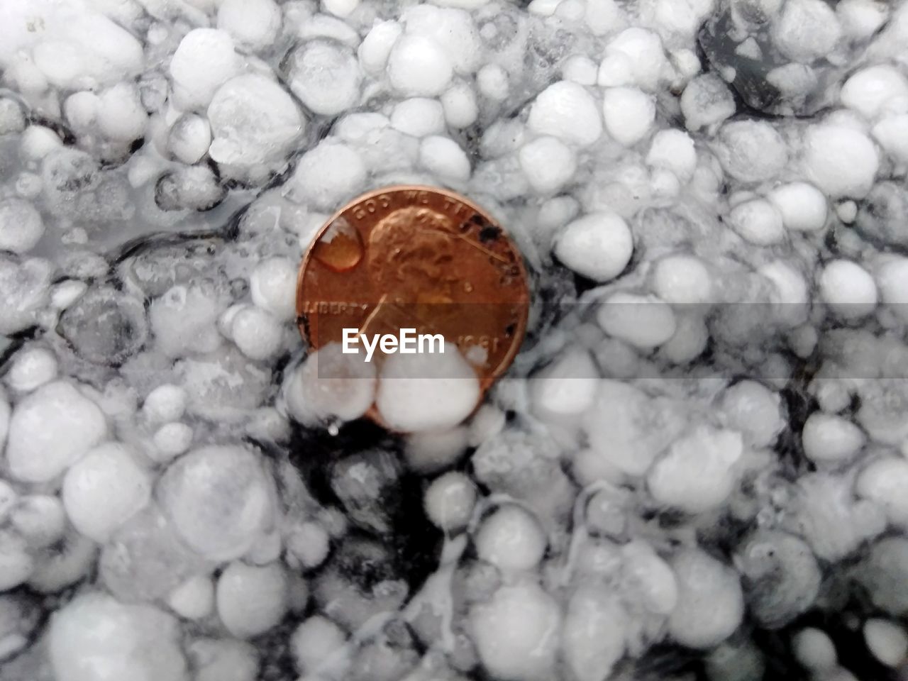 HIGH ANGLE VIEW OF PEBBLES ON WHITE SURFACE