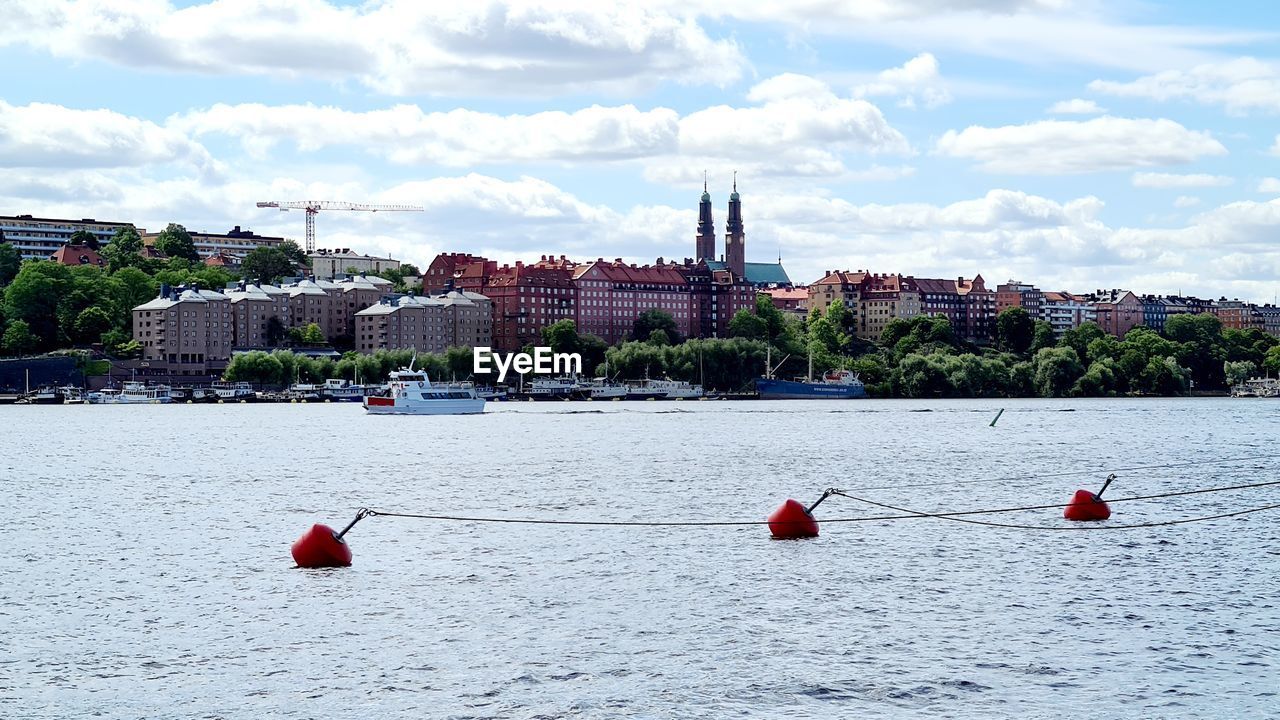 BOATS IN RIVER AGAINST BUILDINGS