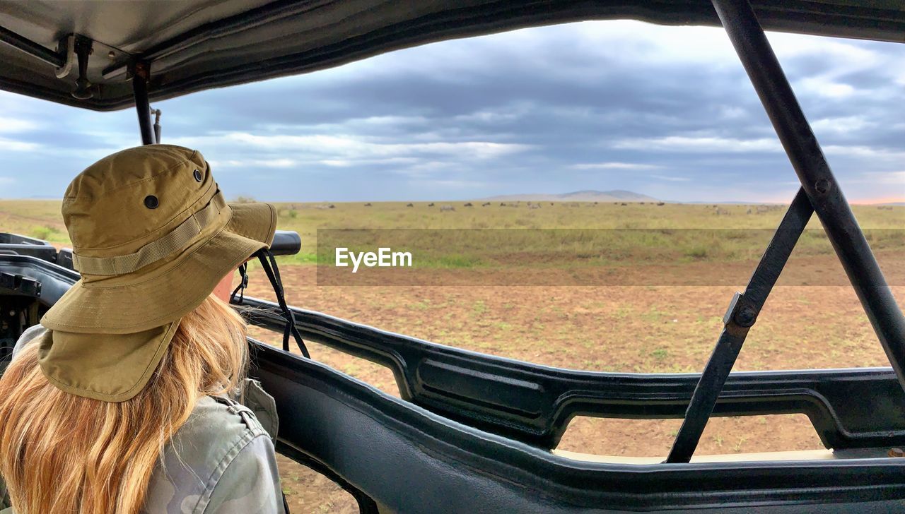 Rear view of woman in car against sky