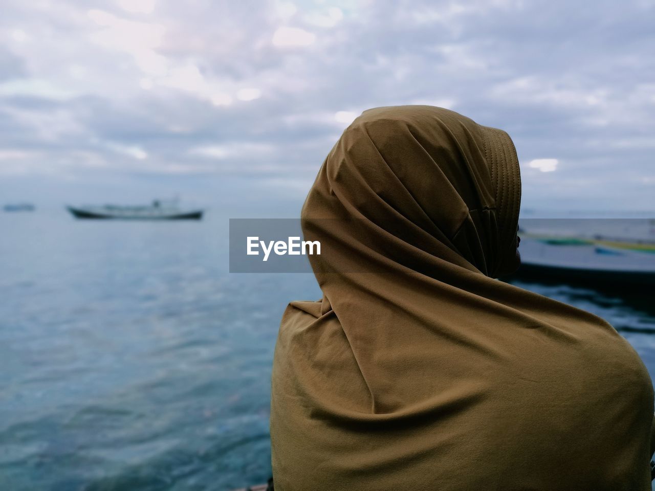 Rear view of woman looking at sea against sky