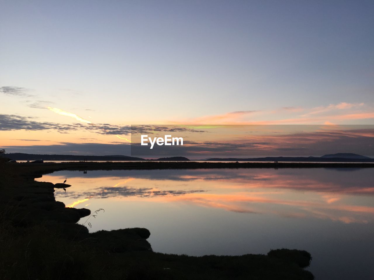 Scenic view of lake against sky during sunset