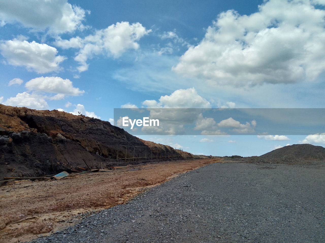 Road leading towards mountains against sky