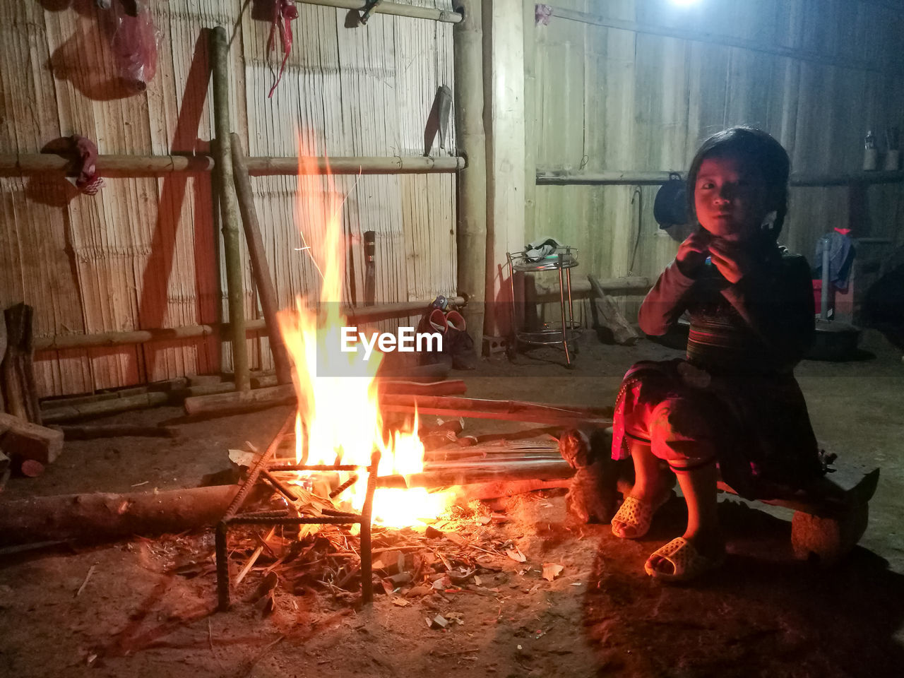 YOUNG WOMAN WITH FIRE AT NIGHT IN ROOM