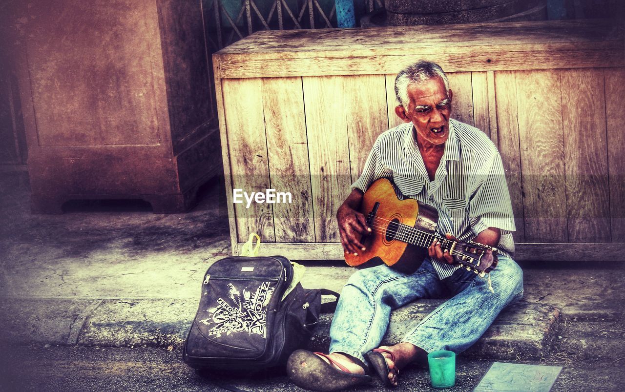 PORTRAIT OF A MAN PLAYING GUITAR IN THE WALL