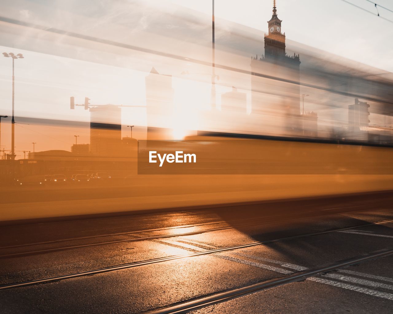 Blurred motion of tram on road in city during sunset