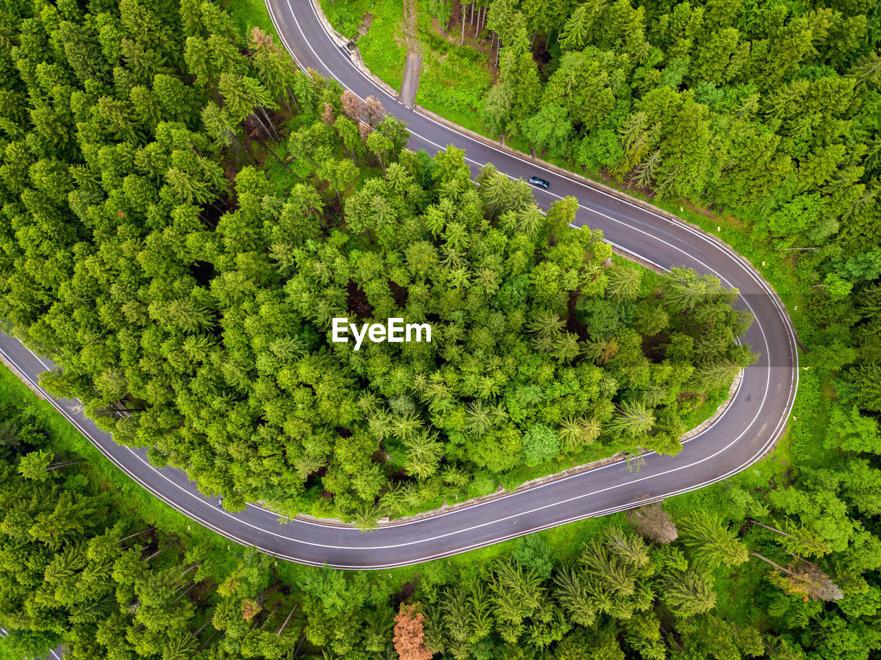 Aerial view of countryside road passing through the forest and mountain