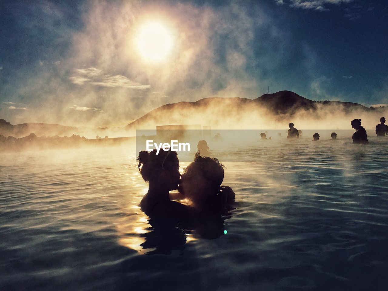 Couple kissing while swimming in hot spring