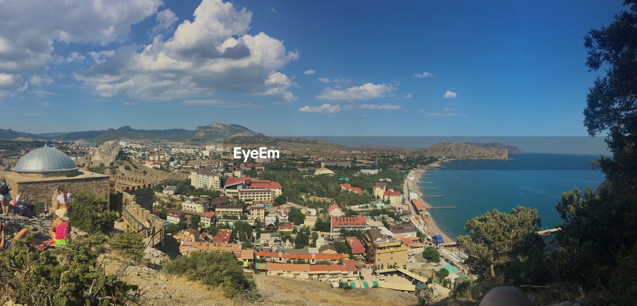 Aerial view of town by sea against sky