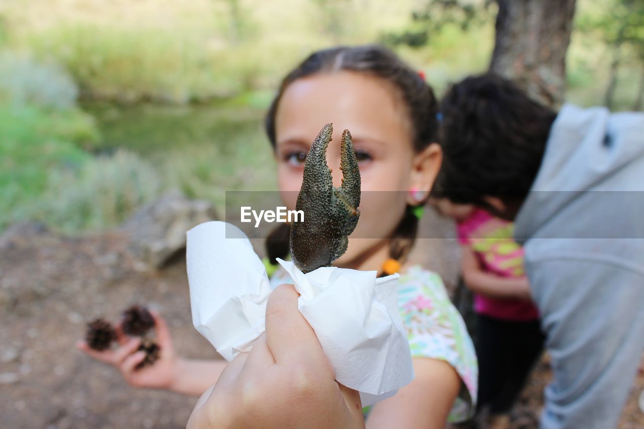 Close-up of girl holding crab claw