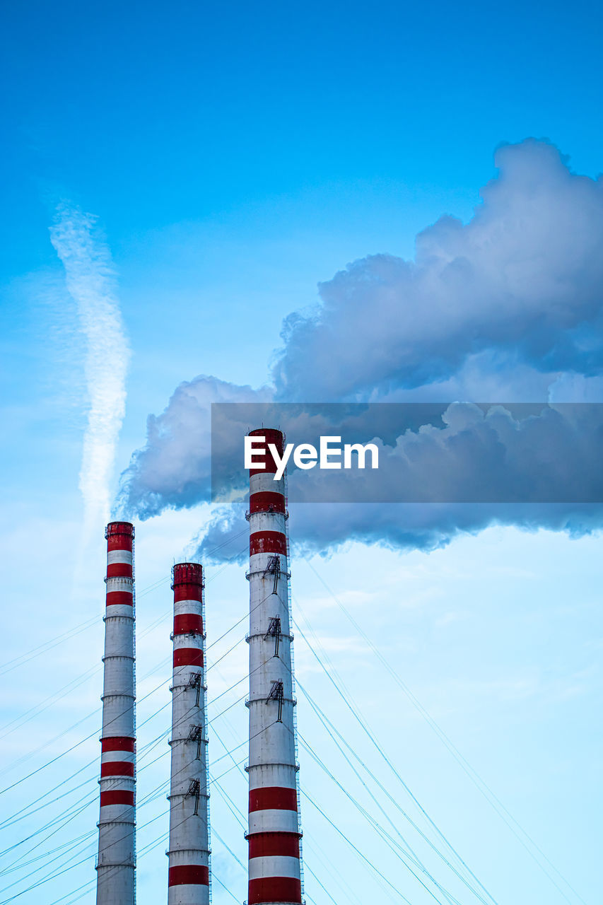 sky, smoke stack, industry, cloud, factory, smoke, power generation, blue, pollution, tower, nature, environmental issues, air pollution, environment, technology, no people, power station, built structure, architecture, day, building exterior, outdoors, electricity, outdoor structure, fumes, poisonous