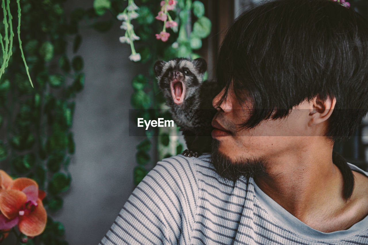 Close-up of young man with meerkat