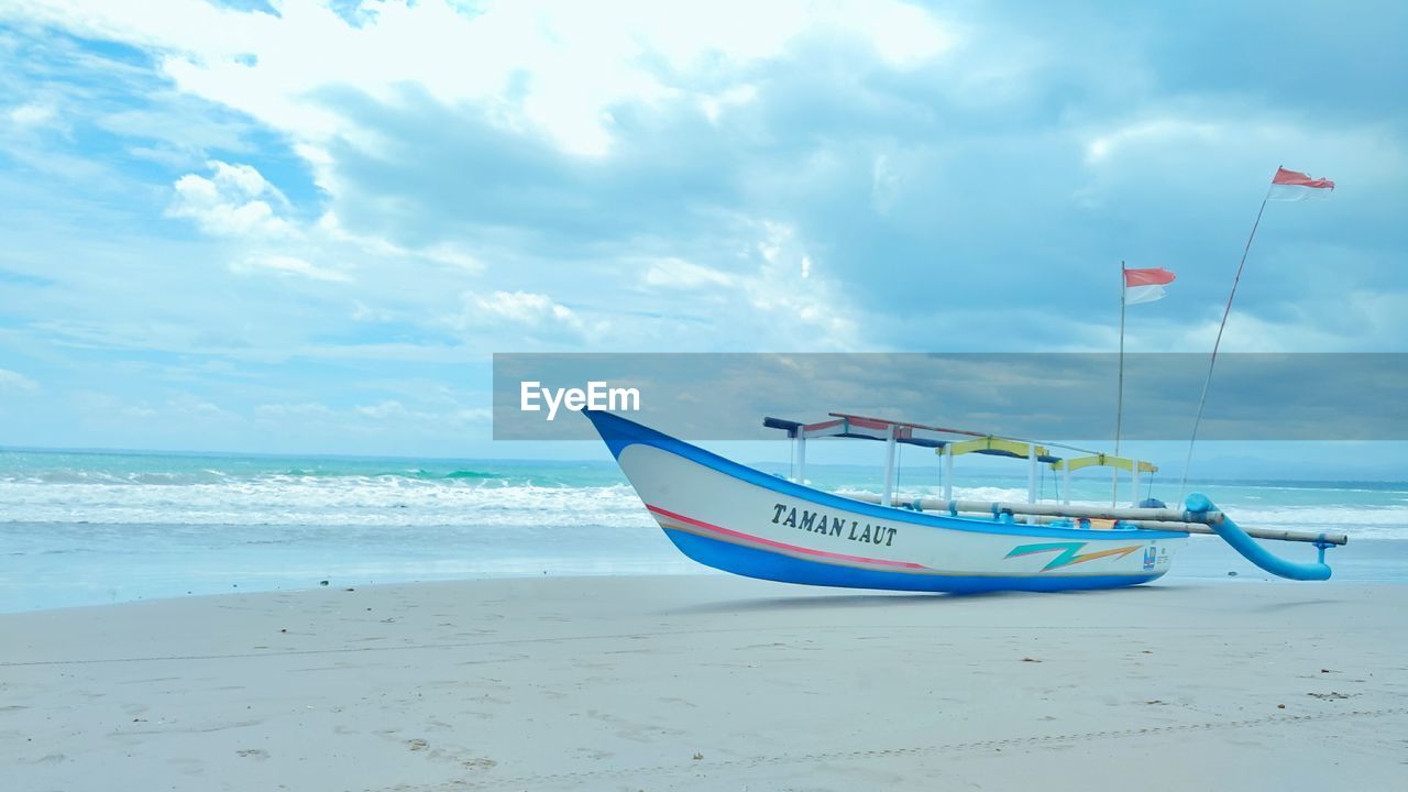 BOAT MOORED AT BEACH