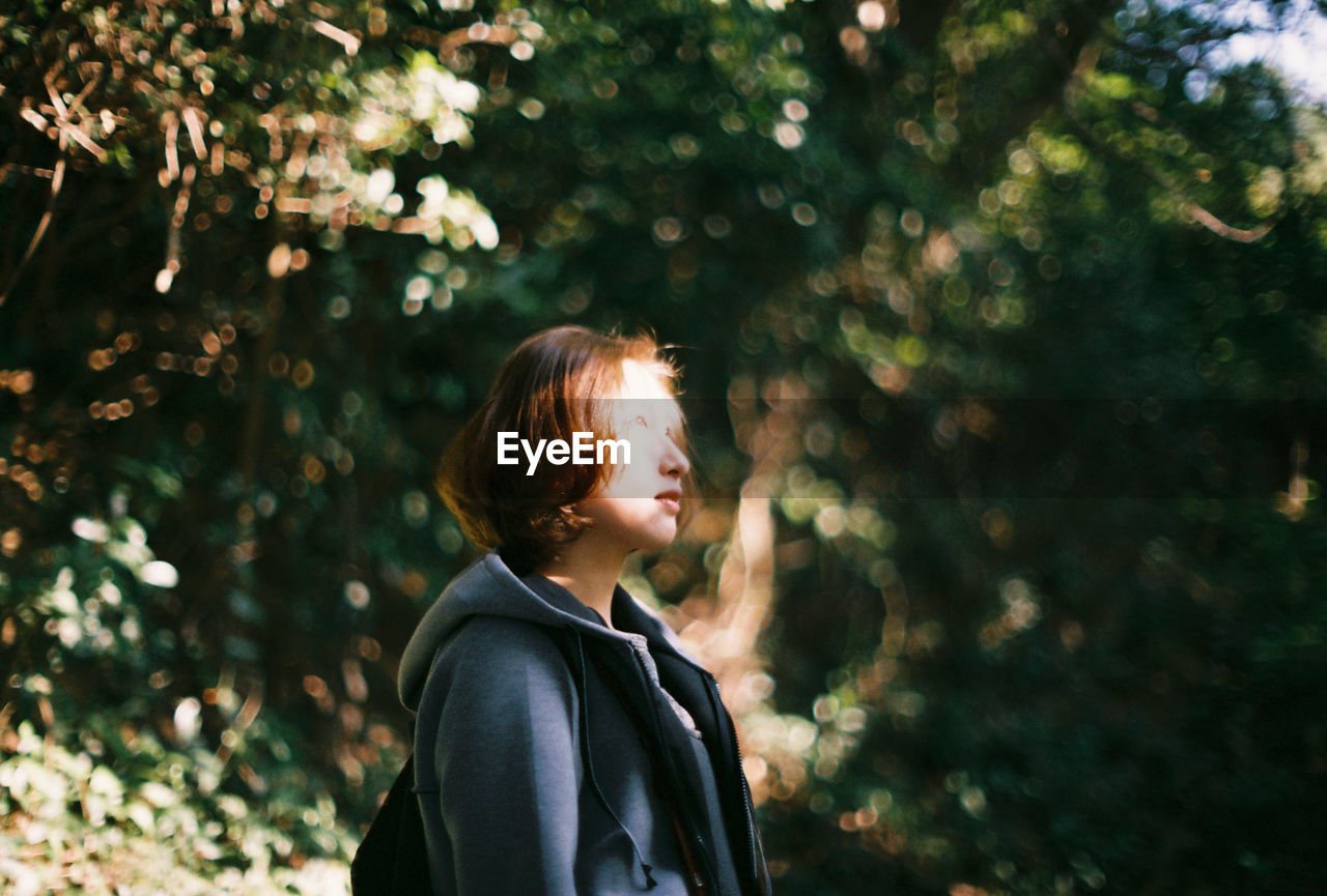 Young woman looking away in park