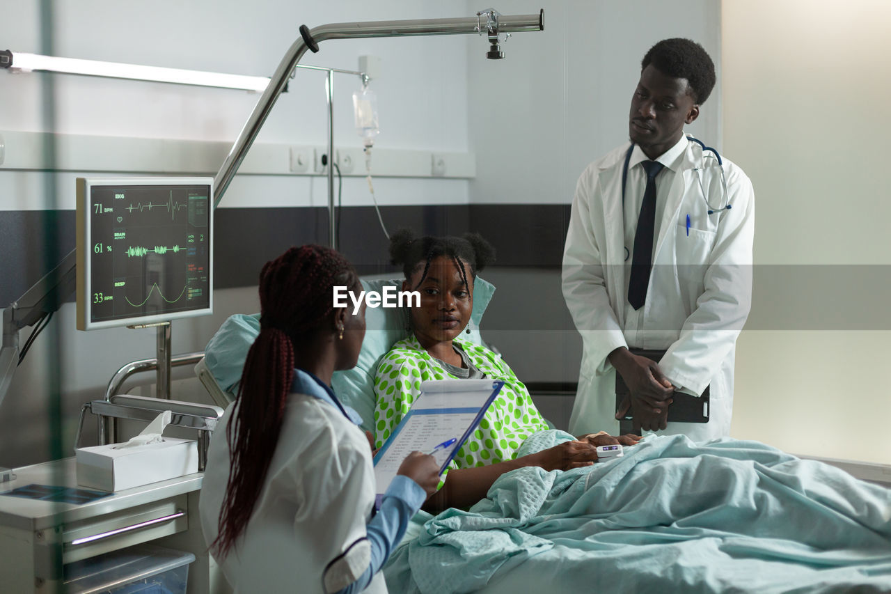 Doctors talking with patient in hospital