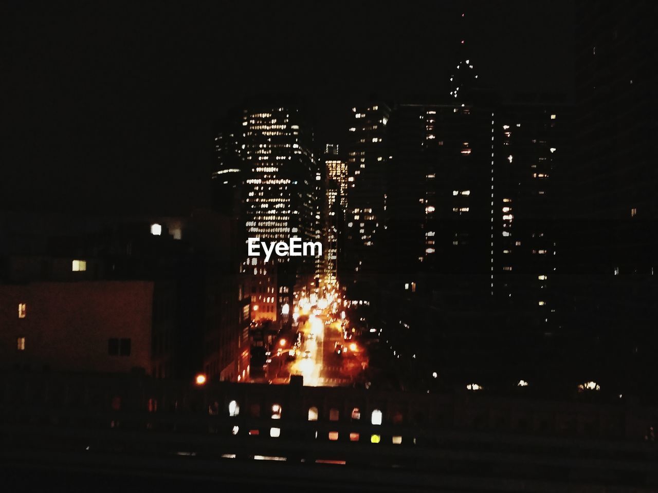 VIEW OF ILLUMINATED CITYSCAPE AT NIGHT