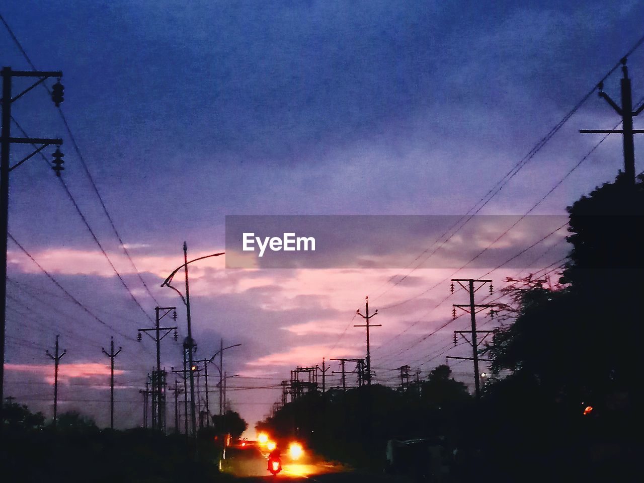 CARS ON STREET AGAINST SKY AT SUNSET