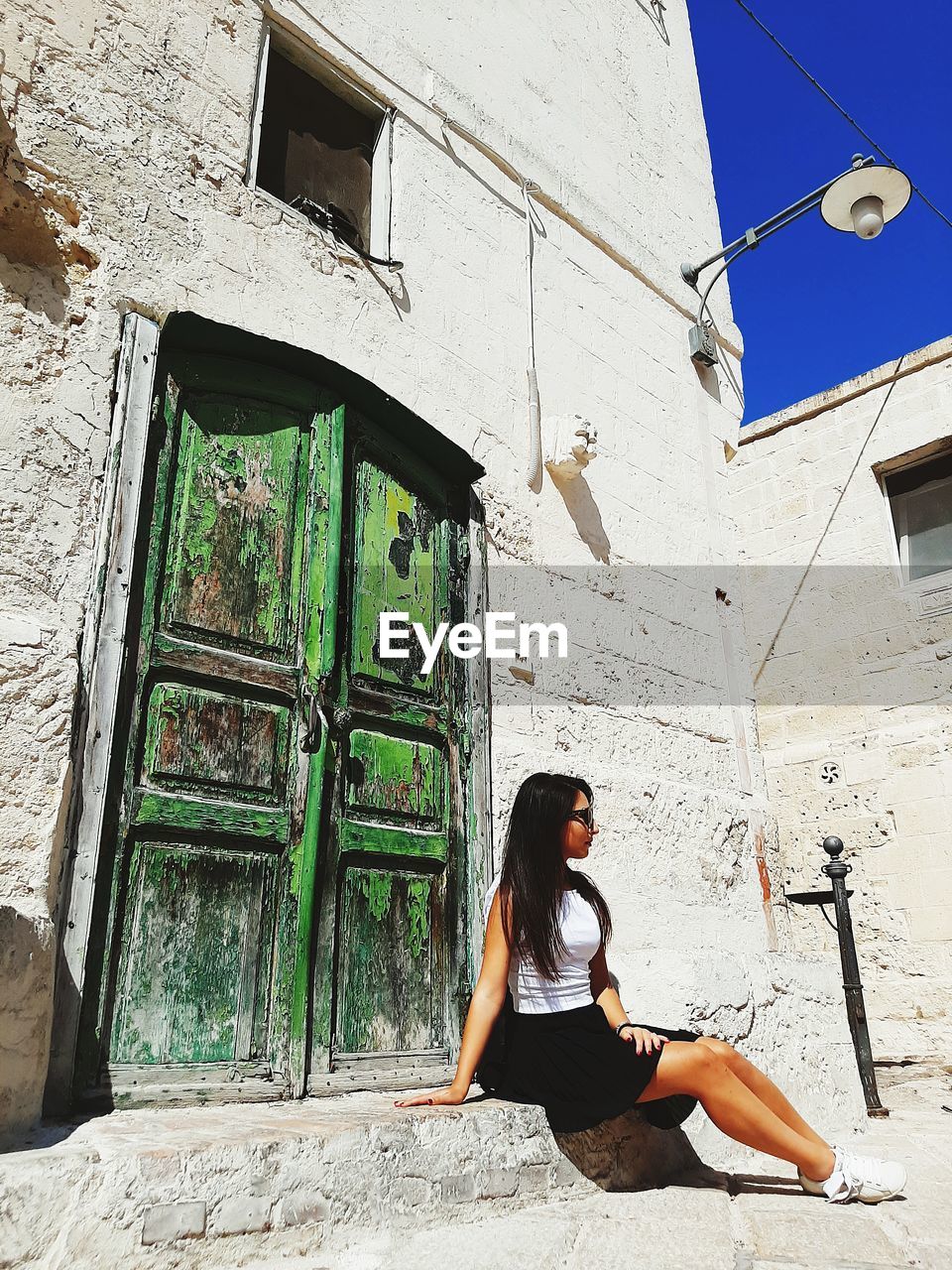 Woman sitting by window of building