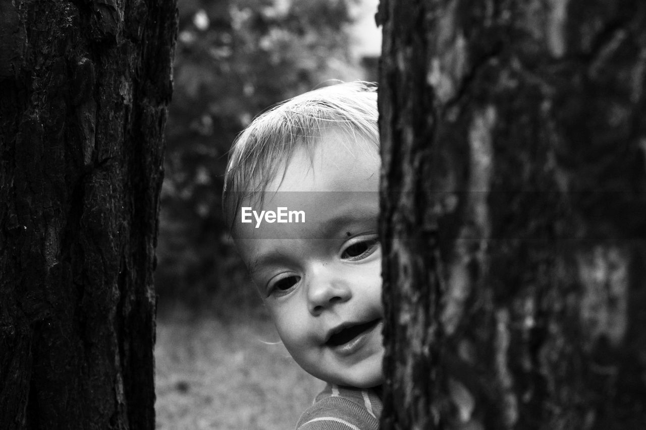 Close-up of cute toddler by tree