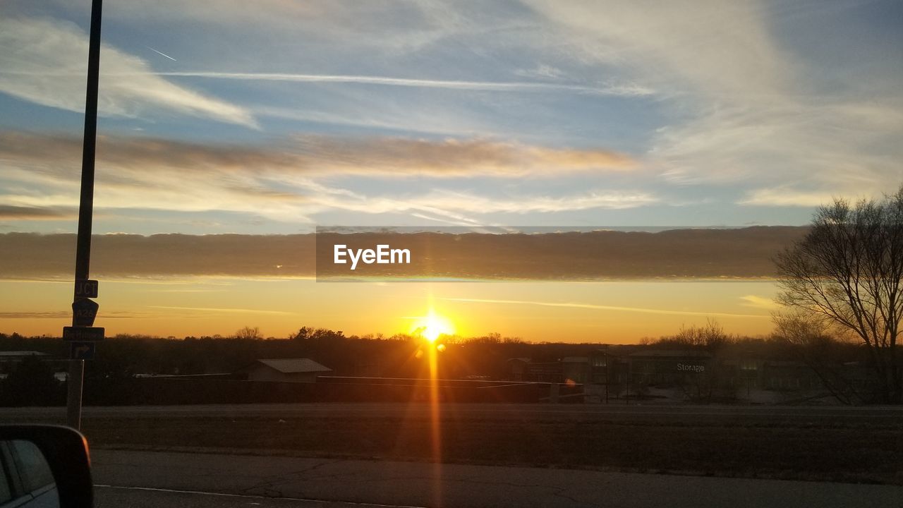 SUNSET OVER ROAD AGAINST SKY DURING ORANGE