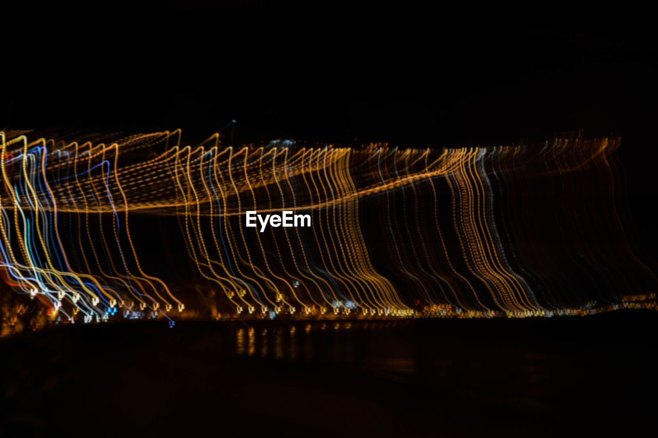 LIGHT TRAILS AGAINST SKY DURING NIGHT