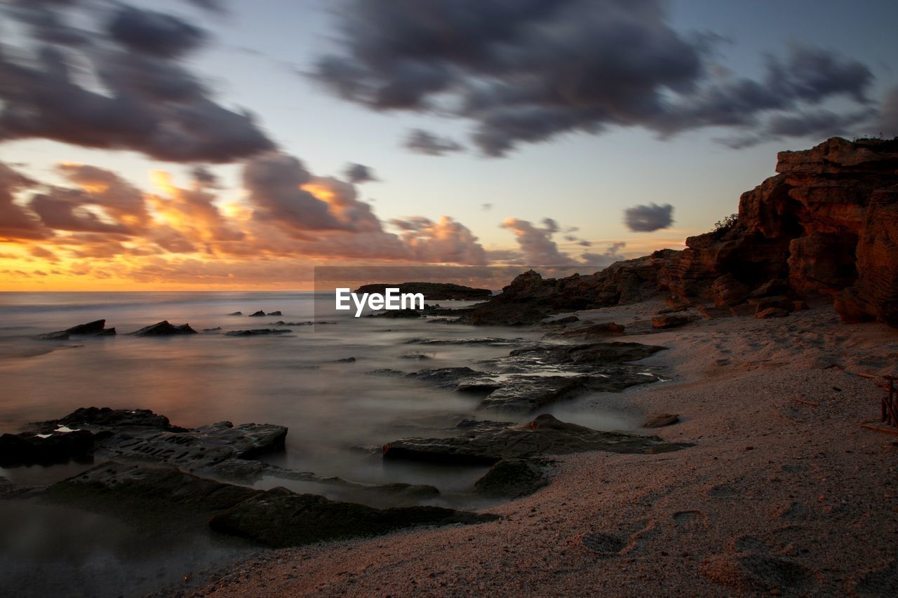 scenic view of beach against sky during sunset