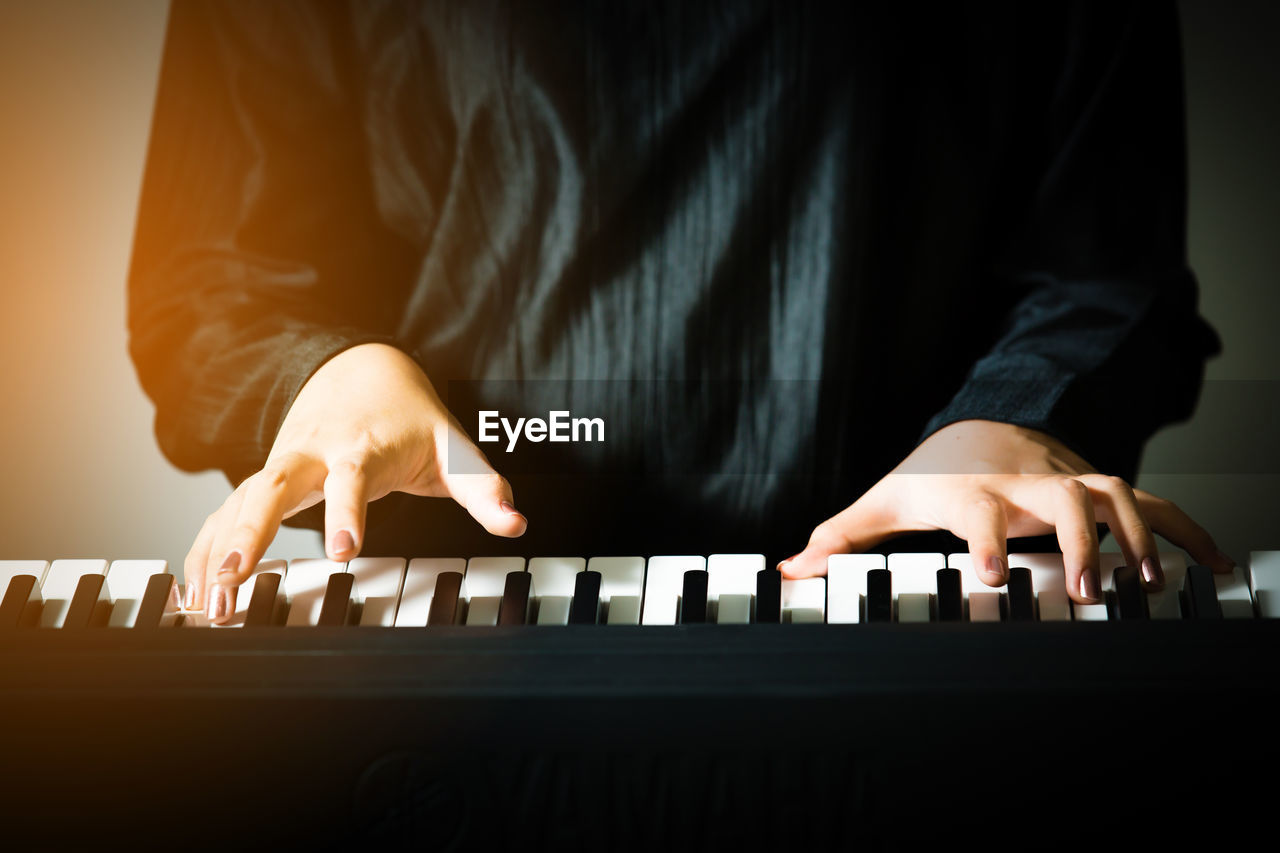 Close-up of hands playing piano