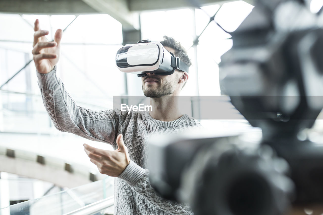 Tech developer wearing virtual reality headset at robotic workshop