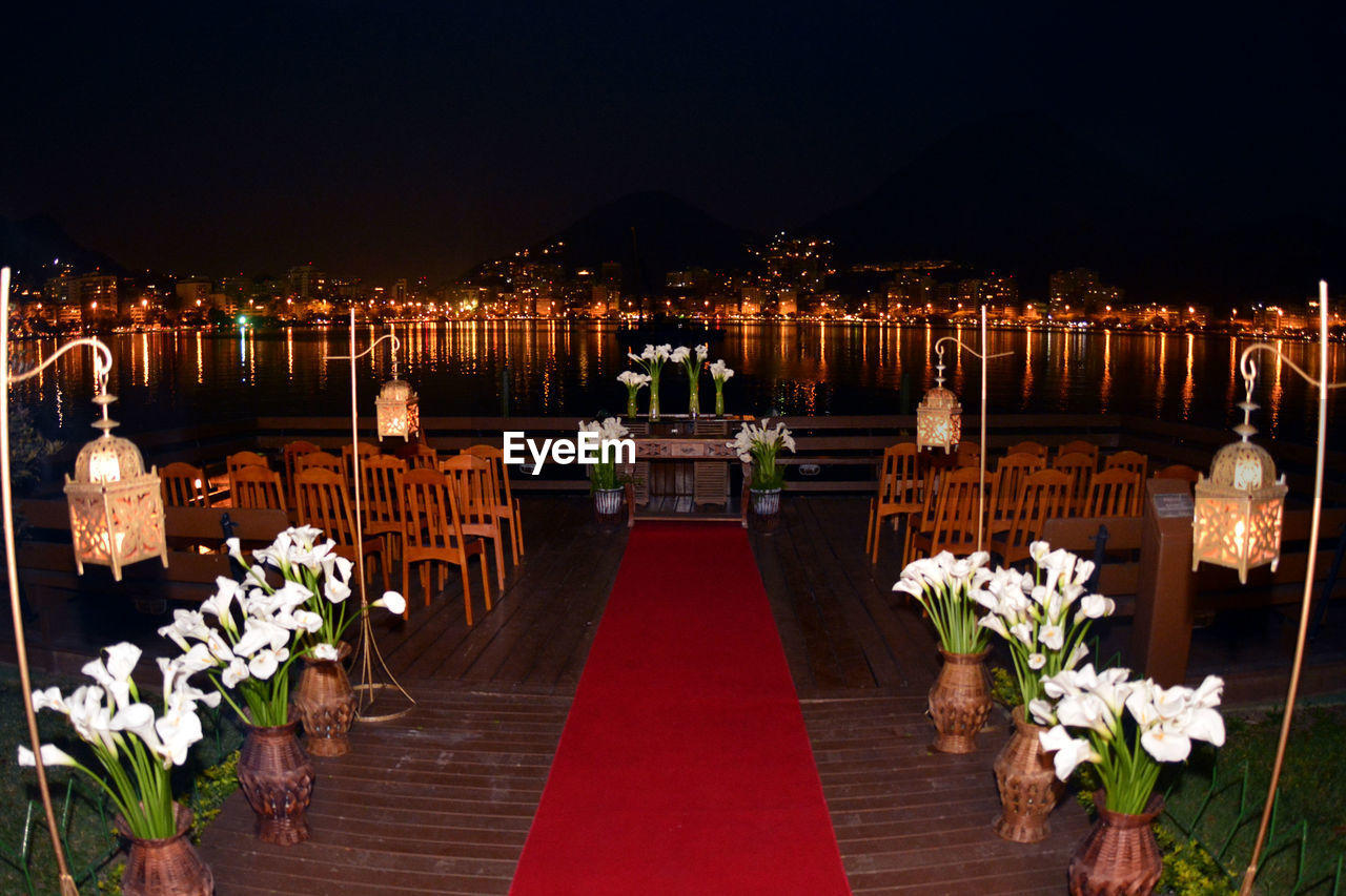 Arrangement of vase and chairs at wedding reception by river