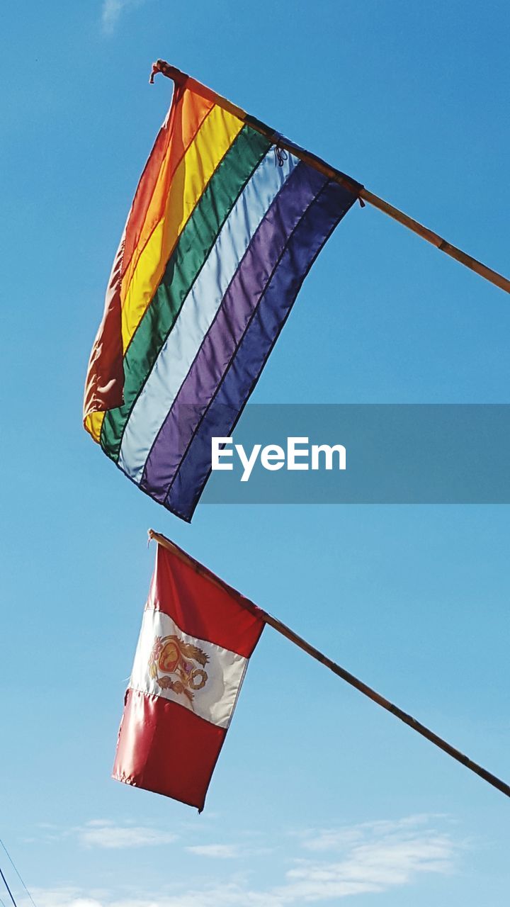 Low angle view of peruvian inka flags against sky