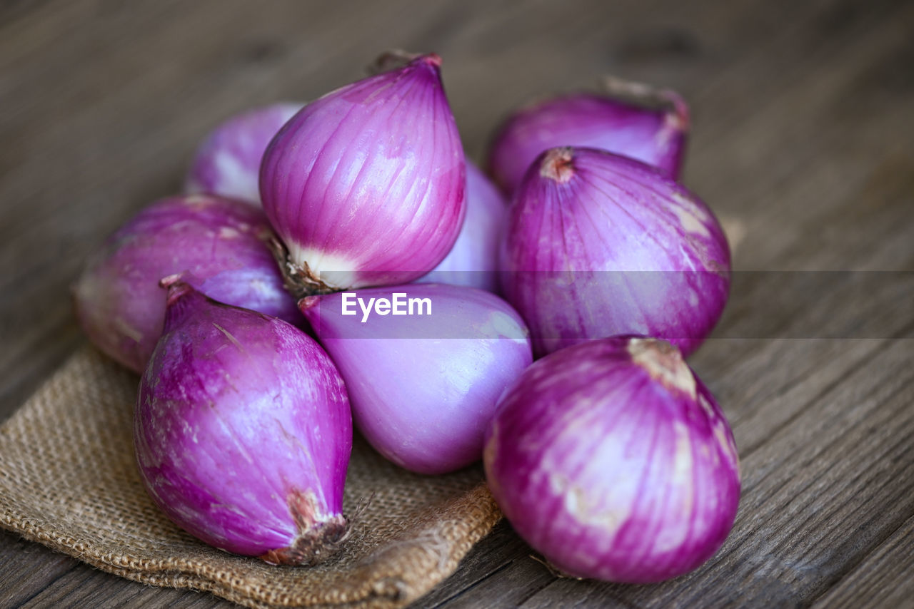 food and drink, food, freshness, healthy eating, wellbeing, plant, vegetable, wood, produce, purple, flower, shallot, still life, ingredient, indoors, no people, garlic, onion, table, spice, close-up, organic, petal, raw food, spanish onion, studio shot, high angle view, garlic bulb, pink, group of objects, cutting board, focus on foreground