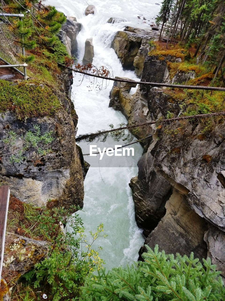 HIGH ANGLE VIEW OF WATERFALL ON RIVERBANK