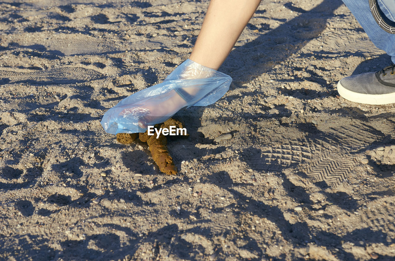 LOW SECTION OF MAN STANDING ON SAND