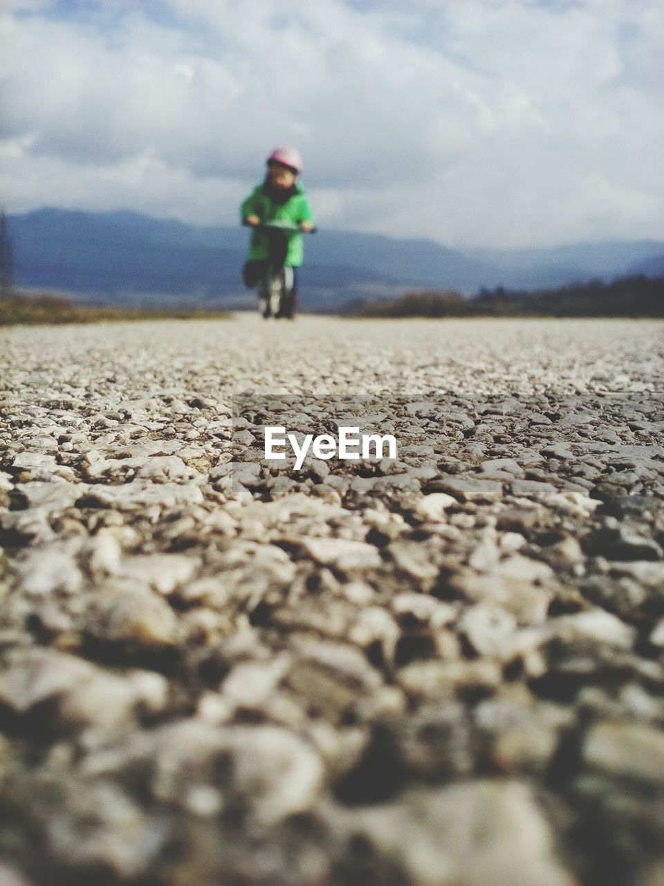 Surface level view of child with bicycle on road