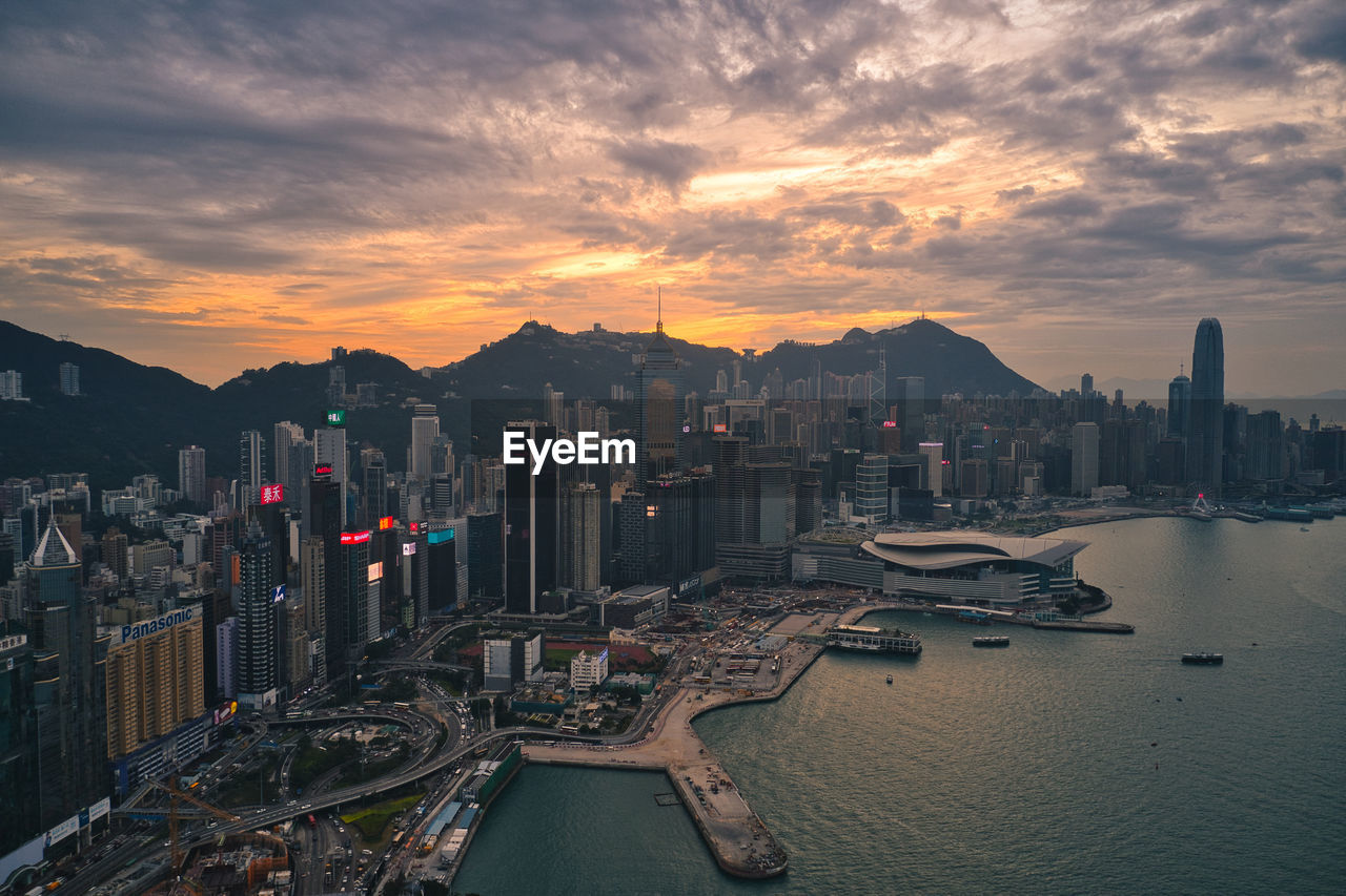 Aerial view of city buildings against sky during sunset