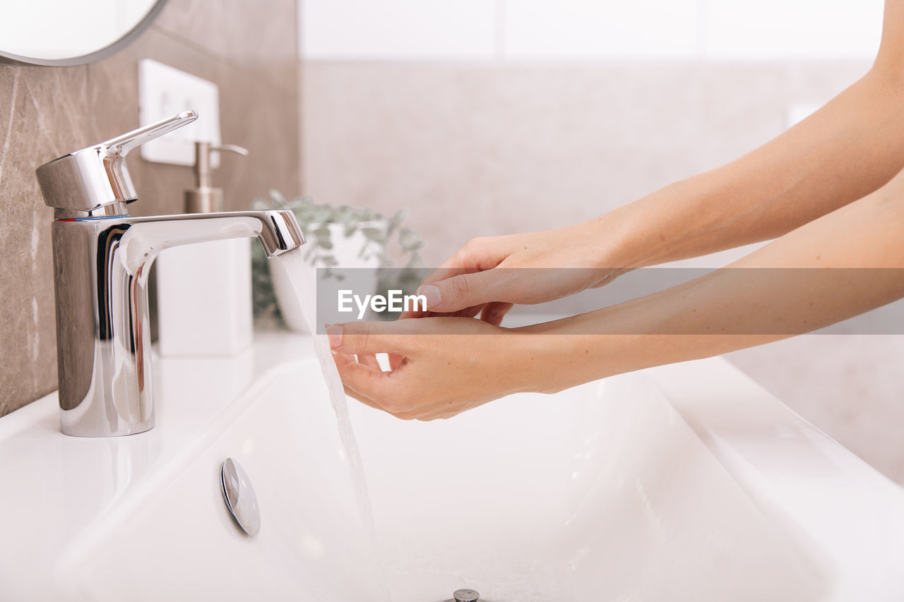 Cropped image of woman washing hands