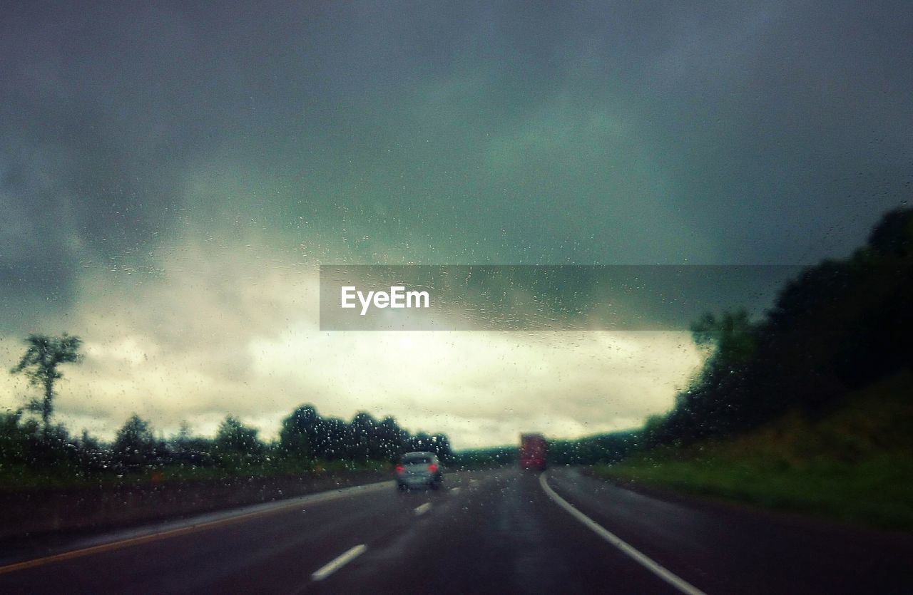 ROAD SEEN THROUGH CAR WINDSHIELD