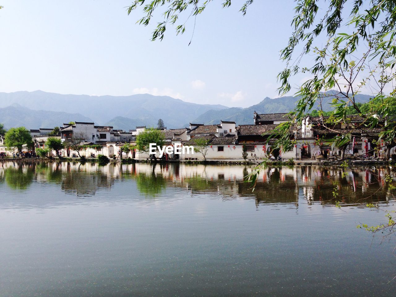 Buildings by lake against sky