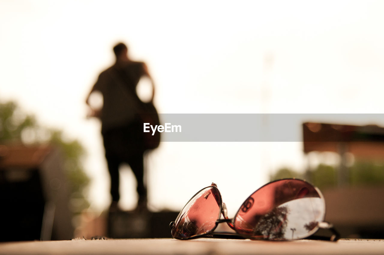 CLOSE-UP OF MAN AND WOMAN STANDING BY SUNGLASSES