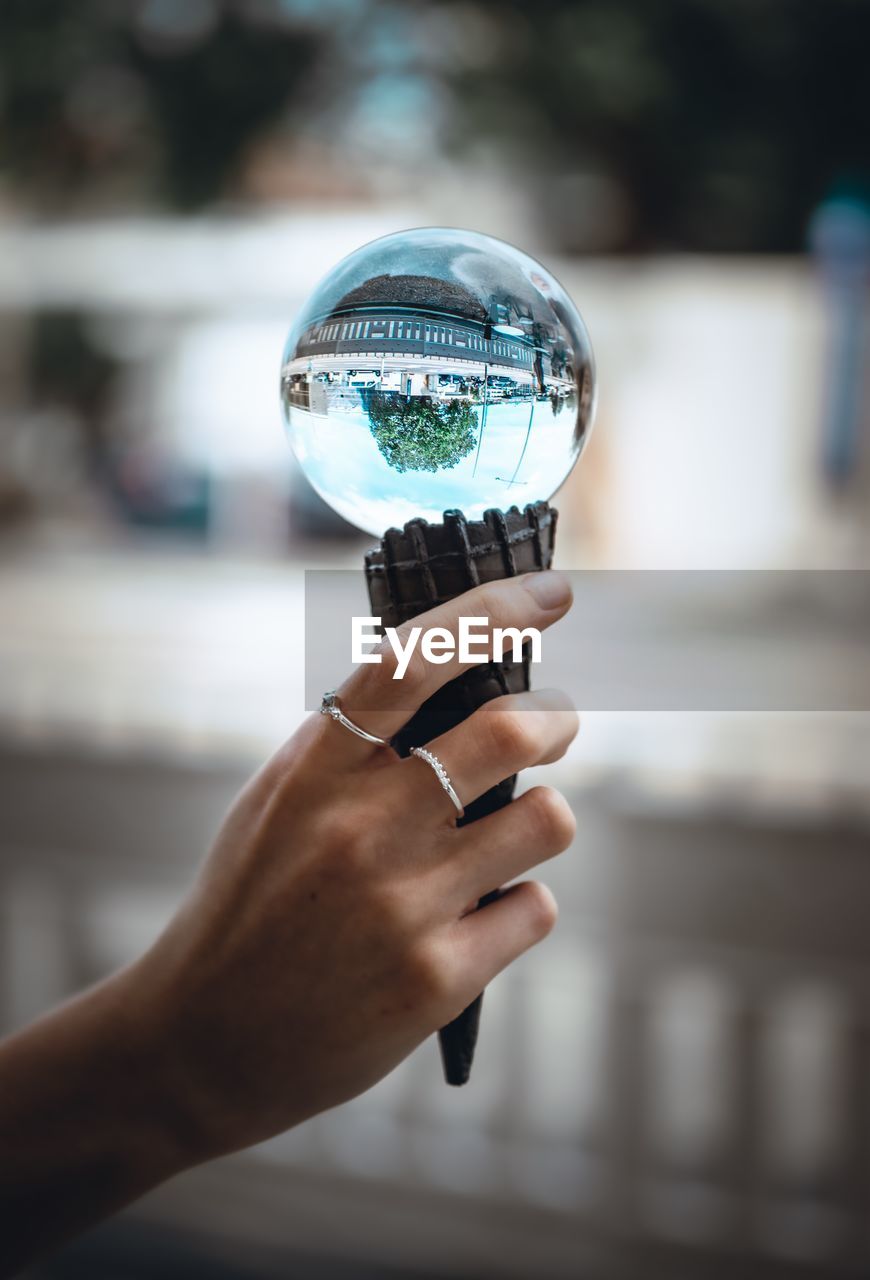 Close-up of hand holding ice cream cone with crystal ball