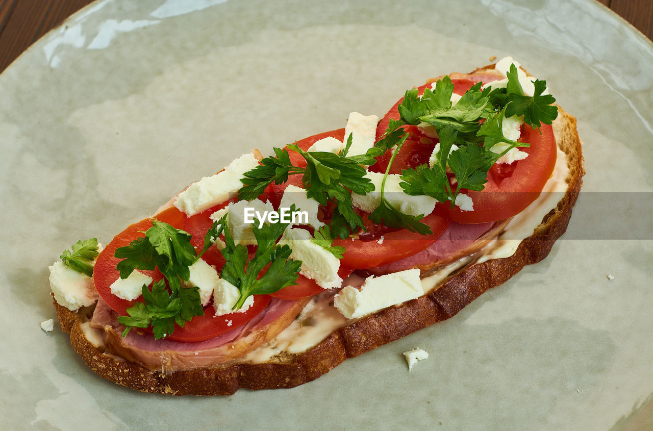 HIGH ANGLE VIEW OF PIZZA SERVED IN PLATE ON TABLE