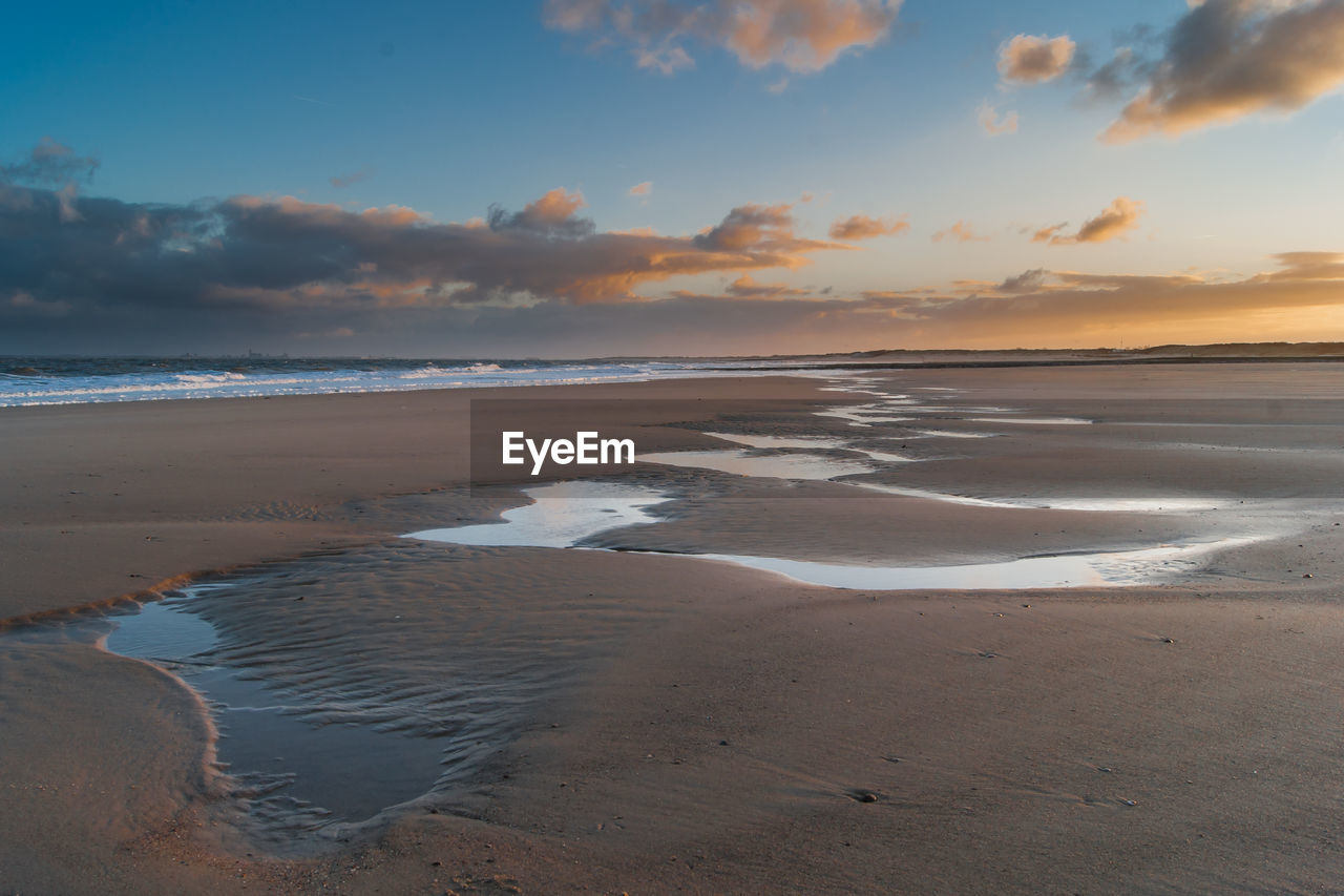 Scenic view of beach against sky during sunset