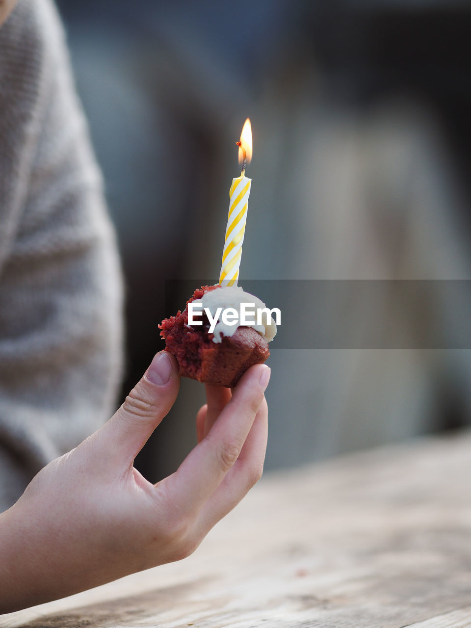 Little boy holding a birthday cake with a lighted candle