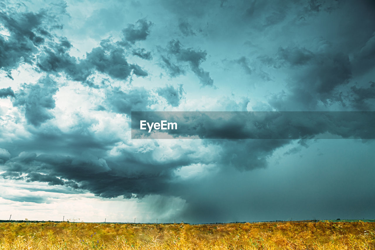 scenic view of field against cloudy sky