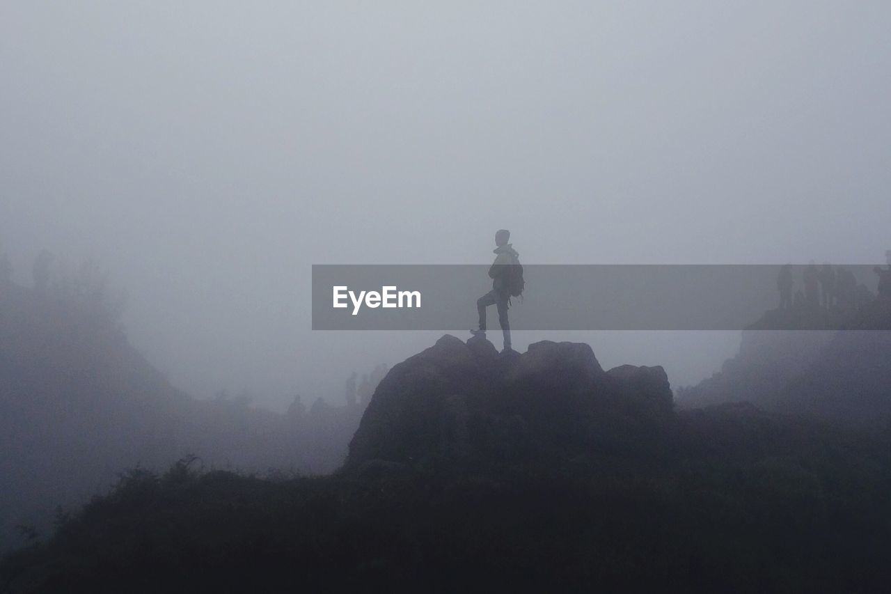 VIEW OF PEOPLE STANDING IN FOGGY WEATHER