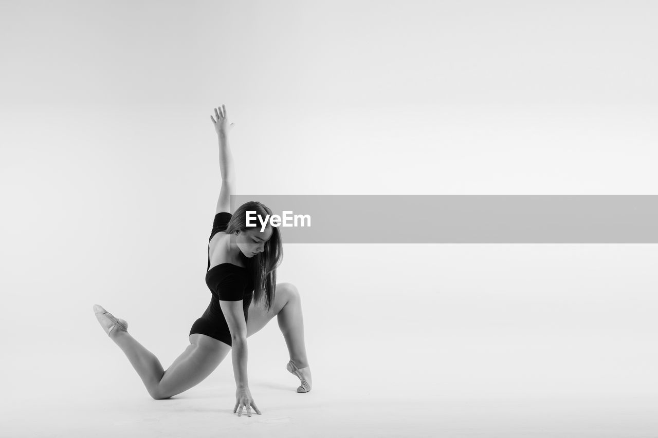 full length of woman doing yoga against clear sky