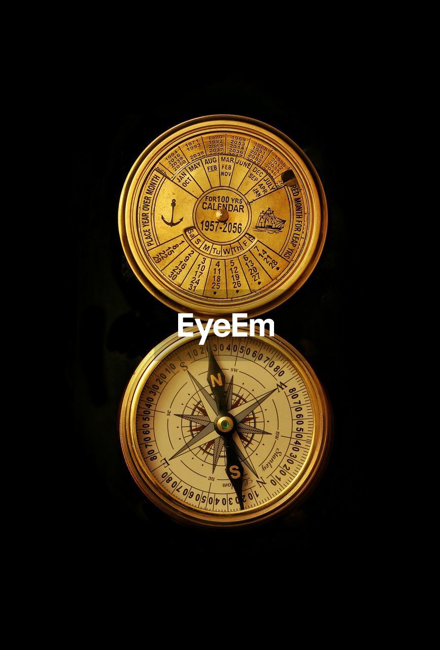 Close-up of navigational compass on black background