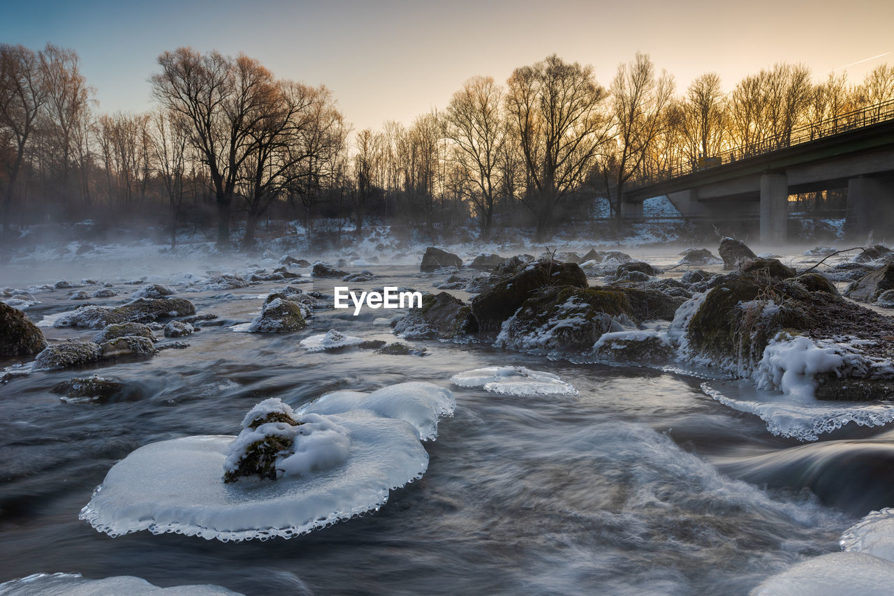 VIEW OF FROZEN RIVER AGAINST SKY DURING WINTER